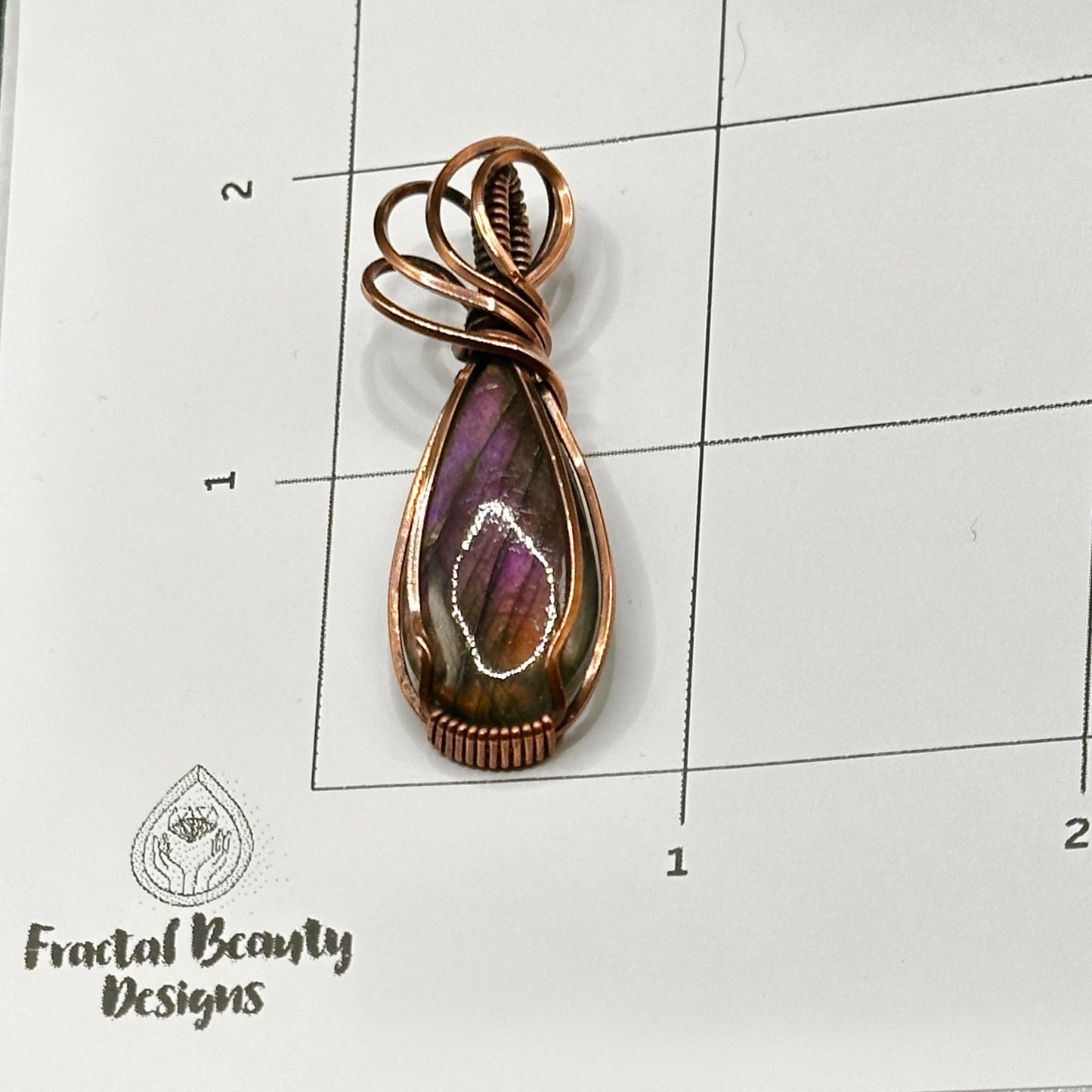 pear shaped purple and orange labradorite stone wrapped in copper