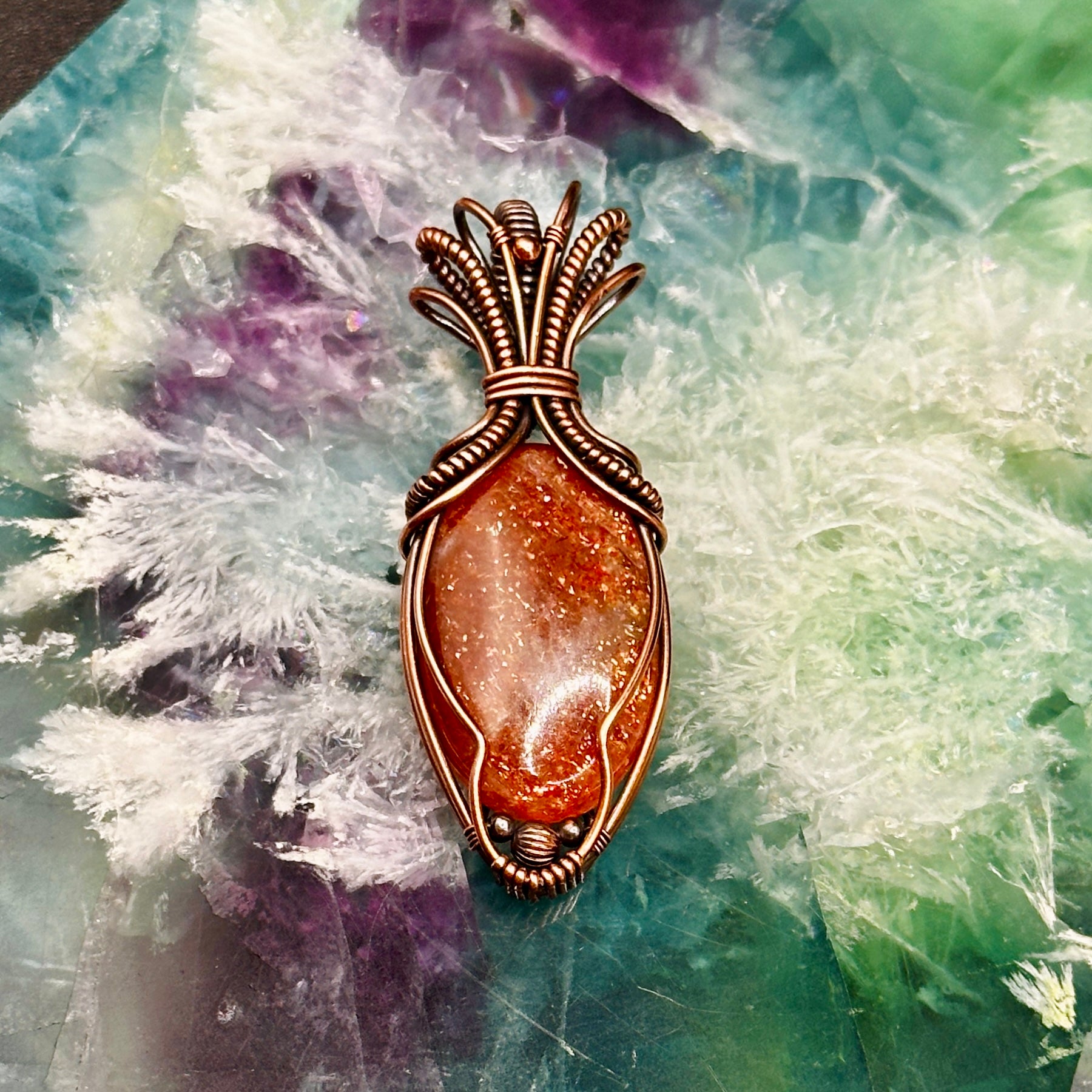 Oval Sunstone wrapped in copper in an "Art deco" design