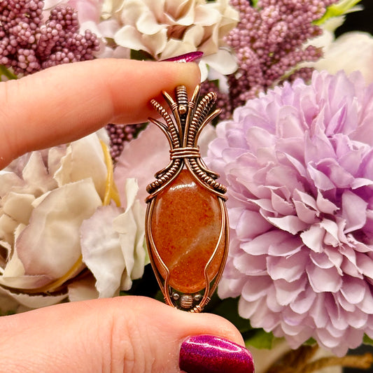 Oval Sunstone wrapped in copper in an "Art deco" design