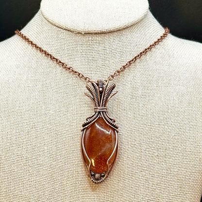 Oval Sunstone wrapped in copper in an "Art deco" design