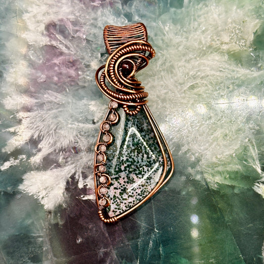 Triangle bloodstone pendant decorated with wavy wire interlaced with rose quartz beads and accented with a garnet bead
