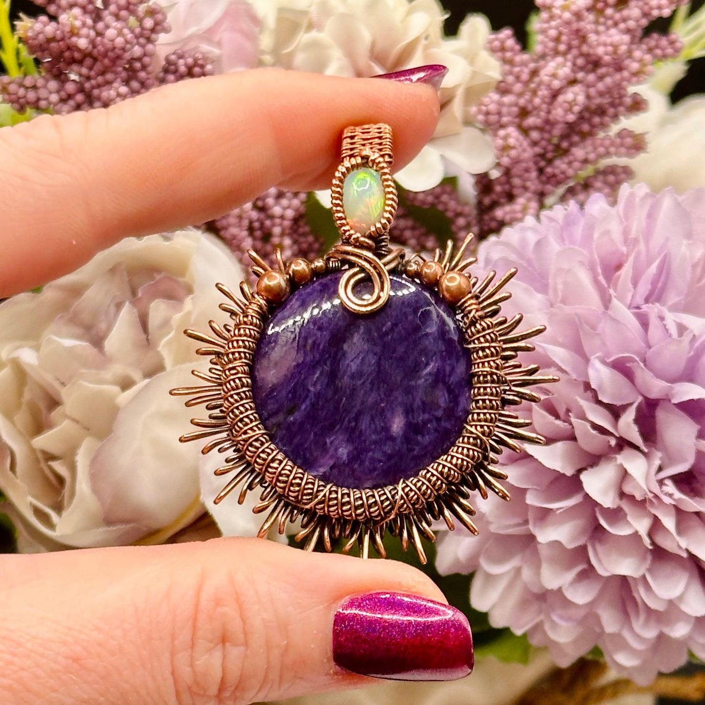 Charoite stone wrapped in sunburst design in antiqued copper accented with a double coil and ethiopian opal