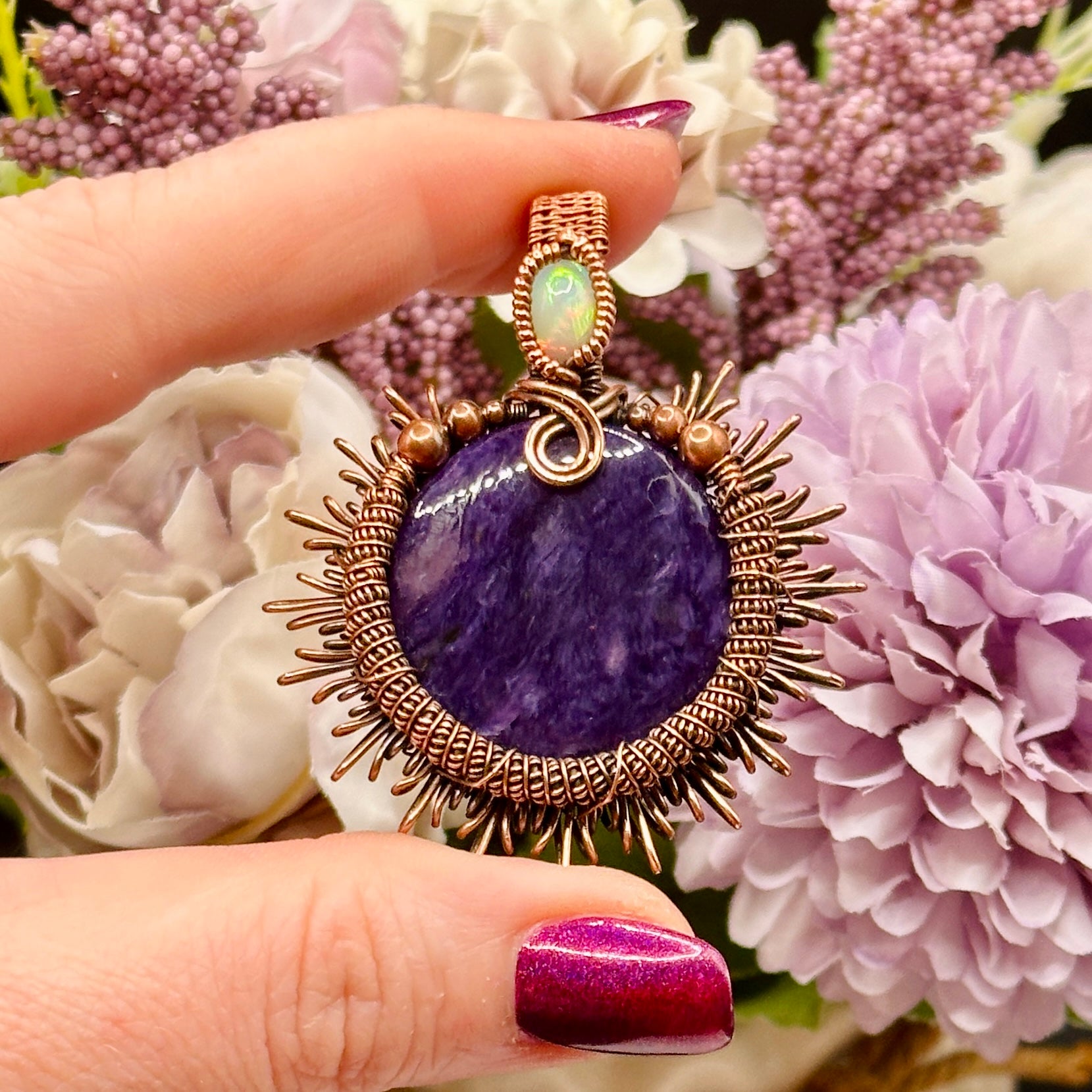 Charoite stone wrapped in sunburst design in antiqued copper accented with a double coil and ethiopian opal