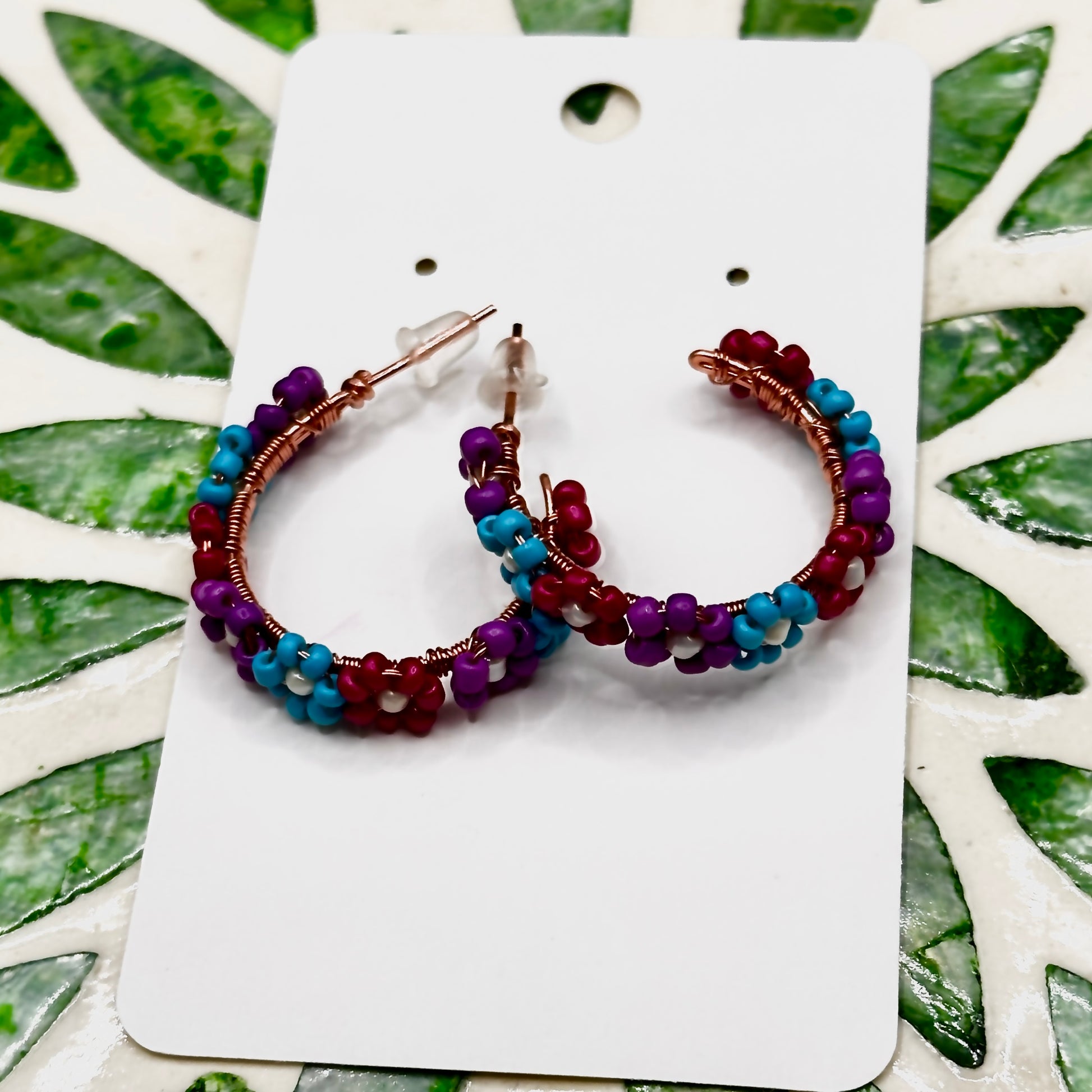 Flower Bead hoop earrings in purple, teal, and dark pink flower designs