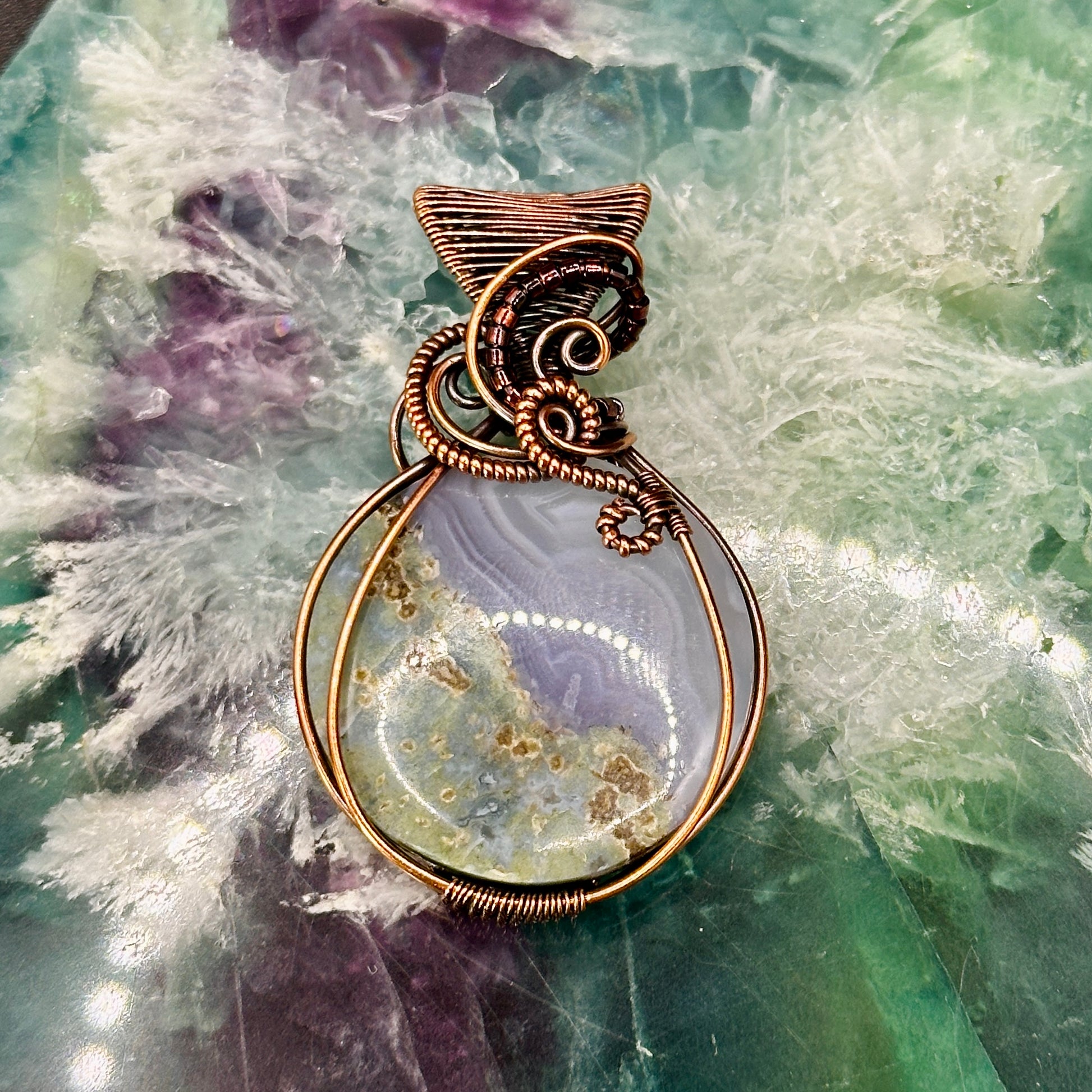 Circular Indonesian Moss Agate stone wrapped in antiqued copper