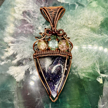 An Iolite Sunstone wrapped in antiuqed copper with 2 Uranium Glass Beads & Fluorite Facet