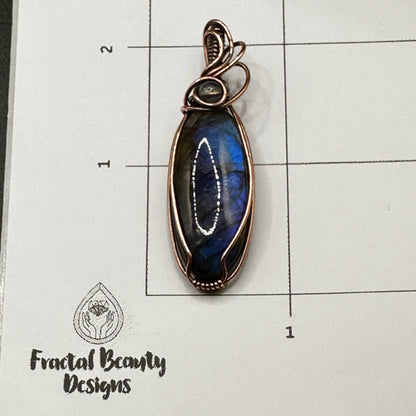 Oval blue labradorite with lab bead on measuring grid