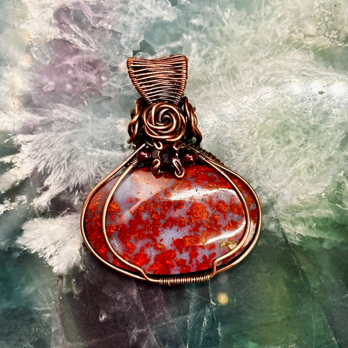 red plume moss agate stone wrapped in antiqued copper with rose and garnet accents 