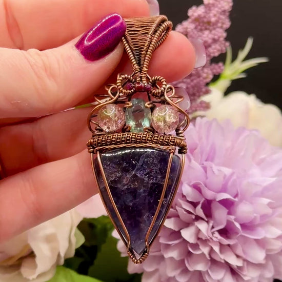Video to show confetti flashes of An Iolite Sunstone wrapped in antiuqed copper with 2 Uranium Glass Beads & Fluorite Facet