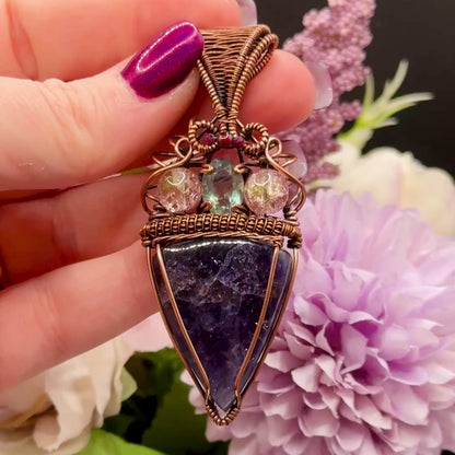 Video to show confetti flashes of An Iolite Sunstone wrapped in antiuqed copper with 2 Uranium Glass Beads & Fluorite Facet